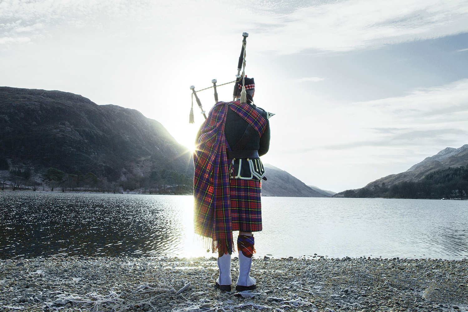 Joueur de cornemuse au levé du soleil au Loch Ness, Écosse